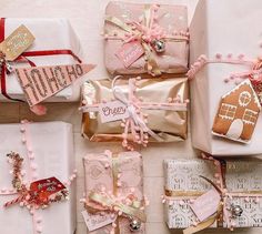 there are many wrapped presents on the table together, including pink and gold wrapping paper