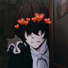 a man holding a raccoon with hearts on his head in front of him