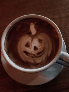 a coffee cup with a smiley face drawn on the foam in it's cappuccino