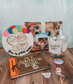 an assortment of personal items are displayed on a wooden table next to a book and bottle