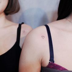 two women with small tattoos on their chests and one has a heart tattoo on her left shoulder