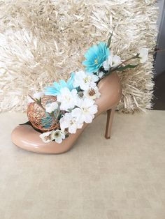 a pair of high heeled shoes with flowers on the side and a basket in the middle