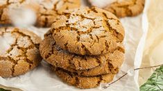 a pile of cookies sitting on top of a piece of wax paper next to some sprigs