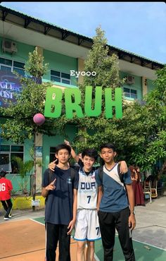 three young men standing in front of a building with the word brouh on it