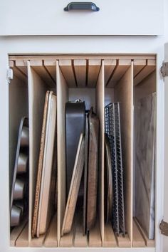 an open drawer with many different types of knives and other items in it on the bottom shelf