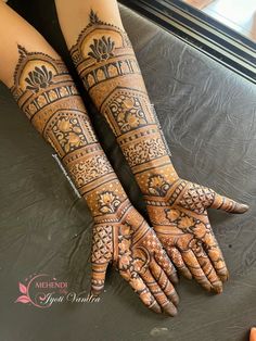 two hands with henna tattoos on them