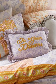 a bed topped with lots of pillows next to a pillow that says i'm your dream