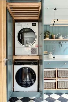 a washer and dryer in a small room with shelves on the wall above them