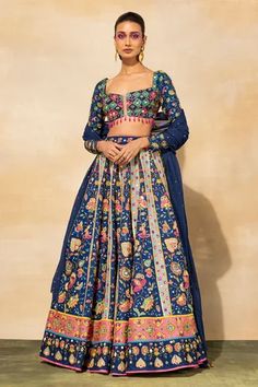 Dark blue lehenga with floral prints, cutdana, mirror embroidery and comes with separate cancan. Paired with printed blouse and dupatta.
Components: 4
Pattern: Printed, Embroidered
Type Of Work: Floral
Neckline: Square
Sleeve Type: Full
Fabric: Raw silk, Lining: Shantoon, mul
Color: Blue
Other Details: 
Tassel details
Back cut-out

Occasion: Wedding - Aza Fashions Square Neck Lehenga, Dark Blue Lehenga, Mirror Embroidery, Blue Lehenga, Embroidered Lehenga, Floral Squares, Embroidered Wedding, Wedding Lehenga, Blue Embroidery