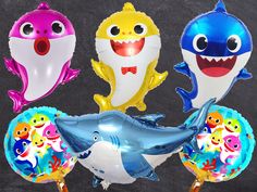 three shark balloons and one dolphin balloon in the shape of an octopus, with other sharks