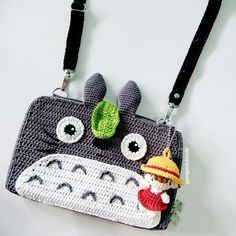 a crocheted purse with an image of a totoro hanging from it