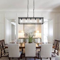 a dining room table with four chairs and a chandelier