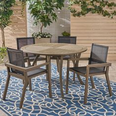 an outdoor table and chairs on a blue rug