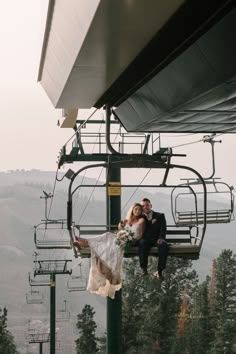 a bride and groom sitting on a chair lift