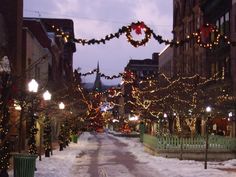 a street is decorated with christmas lights and garlands