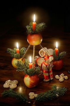 an arrangement of apples, cinnamons and candles in the shape of a christmas tree