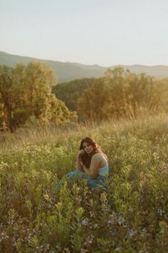 a woman sitting in the middle of a field