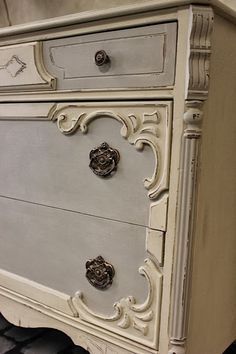 an old white dresser with ornate carvings on the top and bottom, painted in chalk paint