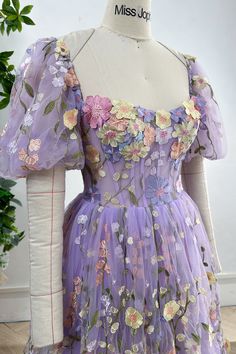 Elevate your style with our Corset Lavender Floral Embroidery Midi Dress. Featuring delicate floral embroidery and elegant puff sleeves, this piece combines femininity and sophistication. Embrace luxury in this exclusive dress. Bust and Skirt with full lining. 100% Polyester 100% Recycled polyester lining Concealed zip at center back Imported Fitted Purple Dress With Floral Applique, Fitted Lavender Embroidered Dress, Lavender Fitted Dress With Puff Sleeves, Lavender Fitted Puff Sleeve Dress, Puff Sleeve Dress With Floral Embroidery For Garden Party, Lavender Floral Embroidered Dress For Spring, Lavender Embroidered Spring Dress, Embroidered Lavender Dress For Spring, Spring Lavender Embroidered Dress