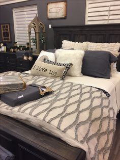 a bed with pillows and blankets on top of it in a room that is advertised for sale