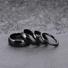 three black rings sitting on top of a gray floor next to each other, with one ring in the middle