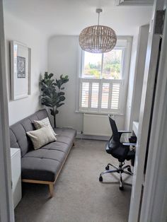 a living room with a couch, computer desk and chair in it's corner