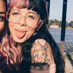 two women with pink hair and glasses posing for the camera