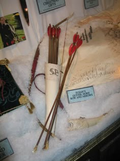 an assortment of items on display in a glass case with white fur and red flowers