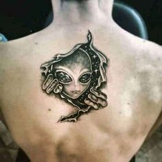 an alien tattoo on the back of a man