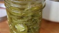 a jar filled with pickles sitting on top of a wooden table