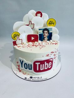 a cake with the words youtube on it is decorated in white frosting and red sprinkles