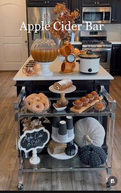 an apple cider bar with donuts, coffee cups and other items on it