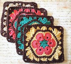 four crocheted coasters are sitting on a table