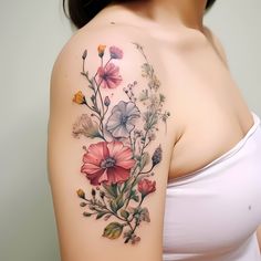 a woman with a flower tattoo on her arm and shoulder is posing for the camera