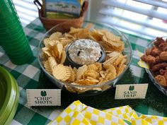 a table topped with bowls filled with chips and dip