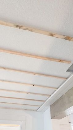 a ceiling fan mounted to the side of a wall in a room with white walls