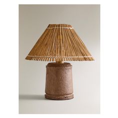 a lamp made out of clay with a bamboo shade on the top, and a white background