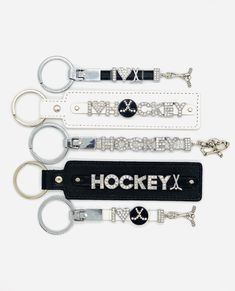 four keychains with the word hockey on them are lined up next to each other