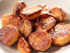 a white plate topped with fried bananas covered in sugar