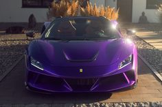 a purple sports car is parked on the side of the road in front of a house