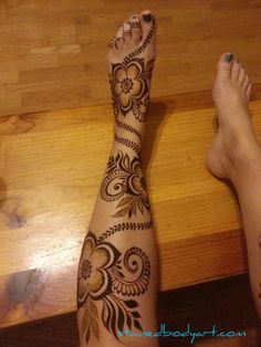 a woman's feet with henna tattoos on them