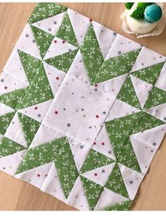 a green and white quilted table topper next to a cupcake on a wooden table