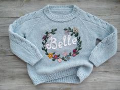 Handmade knitted sweater with name embroidery for baby, girl and boy. Custom soft Wool knit for children.Please write in your personal messages when buying: 1. the name of the childThe sweater is very light and airy, while very warmYour baby's name is embroidered in the center of a circle of flowers.Please write in what color palette you would like to embroider flowers.The palette will be selected depending on your wishes and the combination with the main color of the sweater.I will DEFINITELY s Embroidery For Baby Girl, Embroidery For Baby, Sweater With Name, How To Embroider Letters, Sweater Tutorial, Baby Sweater Patterns, Simple Sweaters, Embroidery Sweater, Name Embroidery