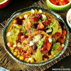 a bowl filled with mexican food next to bowls of salsa and guacamole