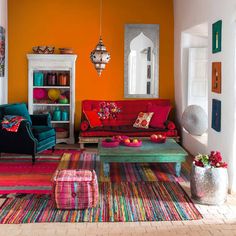 a living room filled with colorful furniture and decor on top of carpeted flooring