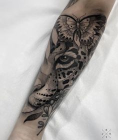 a black and white tattoo on the arm of a person with a butterfly on it