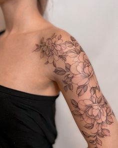 a woman's arm with flowers on it, and the back of her shoulder