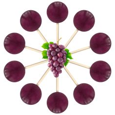 a bunch of grapes sitting on top of wooden skewers with green leaves in the middle