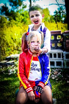 two children dressed as clowns sitting on top of each other