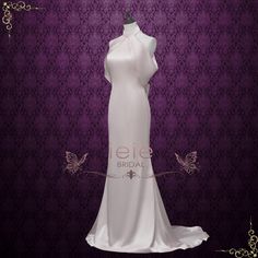 a white wedding dress on display in front of a purple background